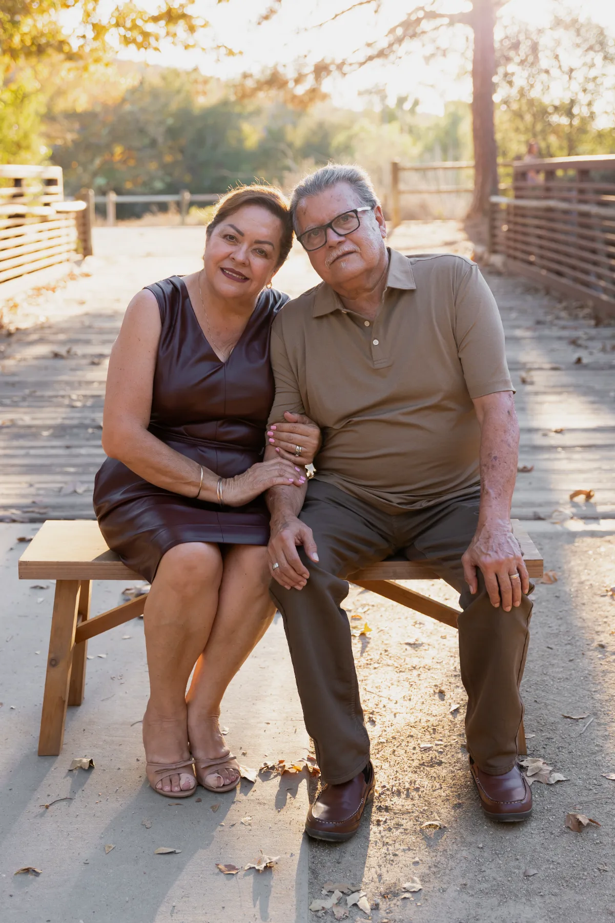 Grandparents seated together on a bench at golden hour