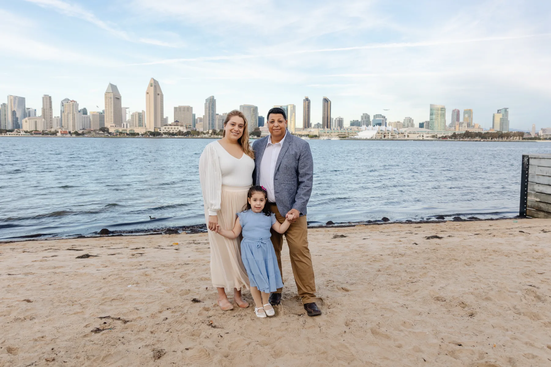 Family of three on the beach with the San Diego skyline, JSOLOVISUALS