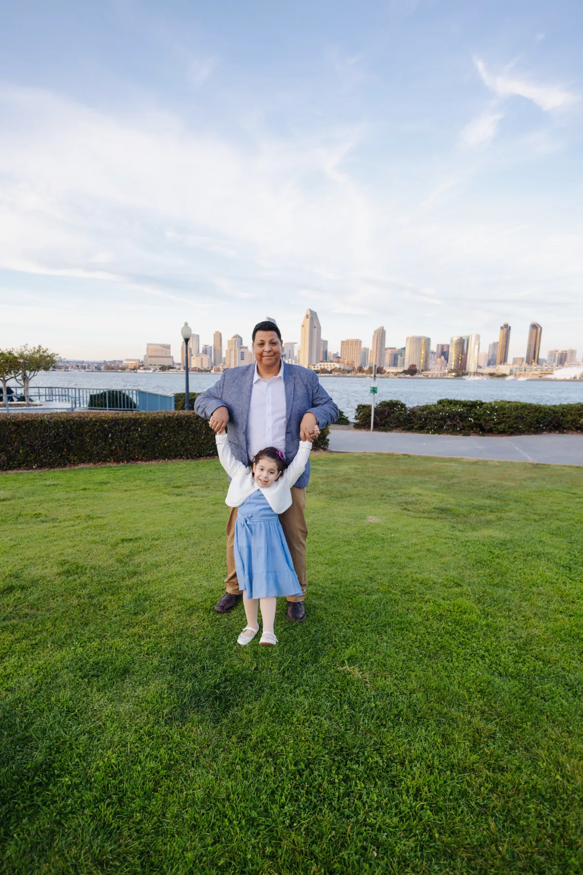 Dad and daughter playing on the lawn with the San Diego skyline, JSOLOVISUALS