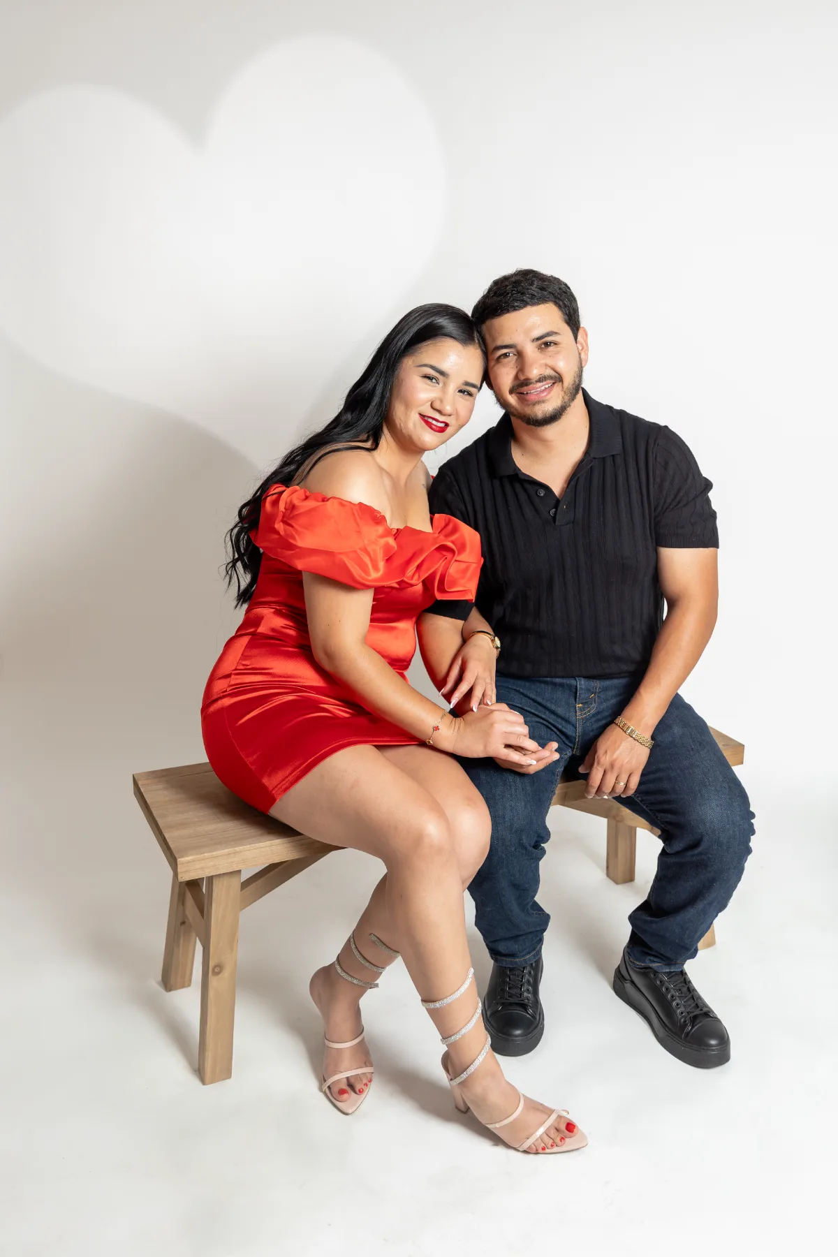 Couple in red and black on a wooden bench in the Poway studio, JSOLOVISUALS