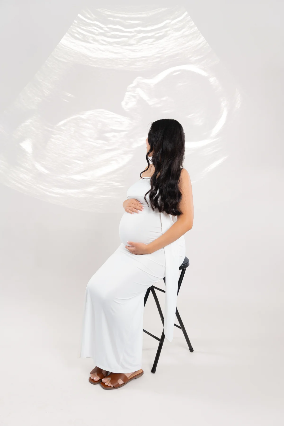 Maternity portrait in a white gown with an ultrasound projection, JSOLOVISUALS studio in Poway, CA