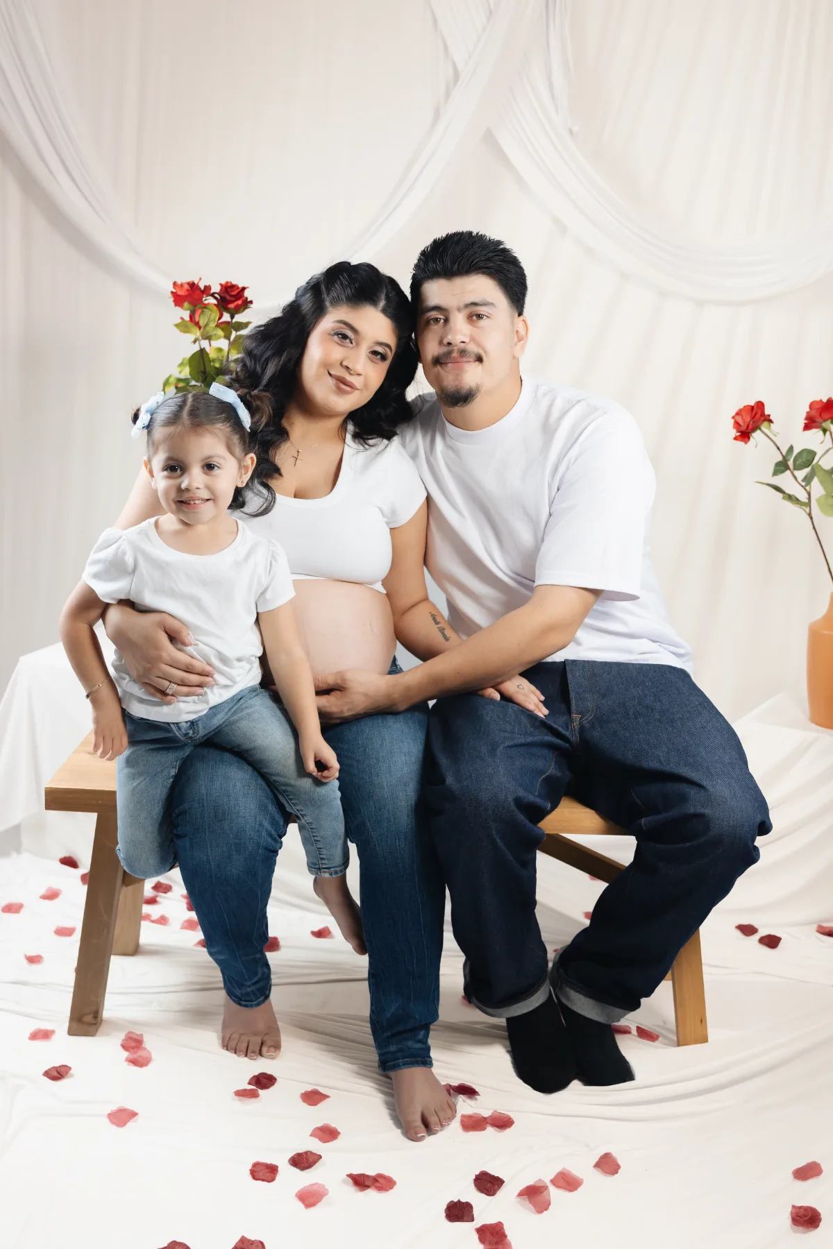 Family maternity portrait on a bench with roses in the Poway studio