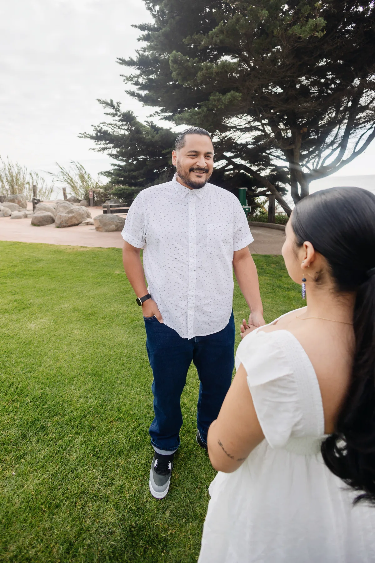 Partner smiling during an outdoor maternity session by the coast