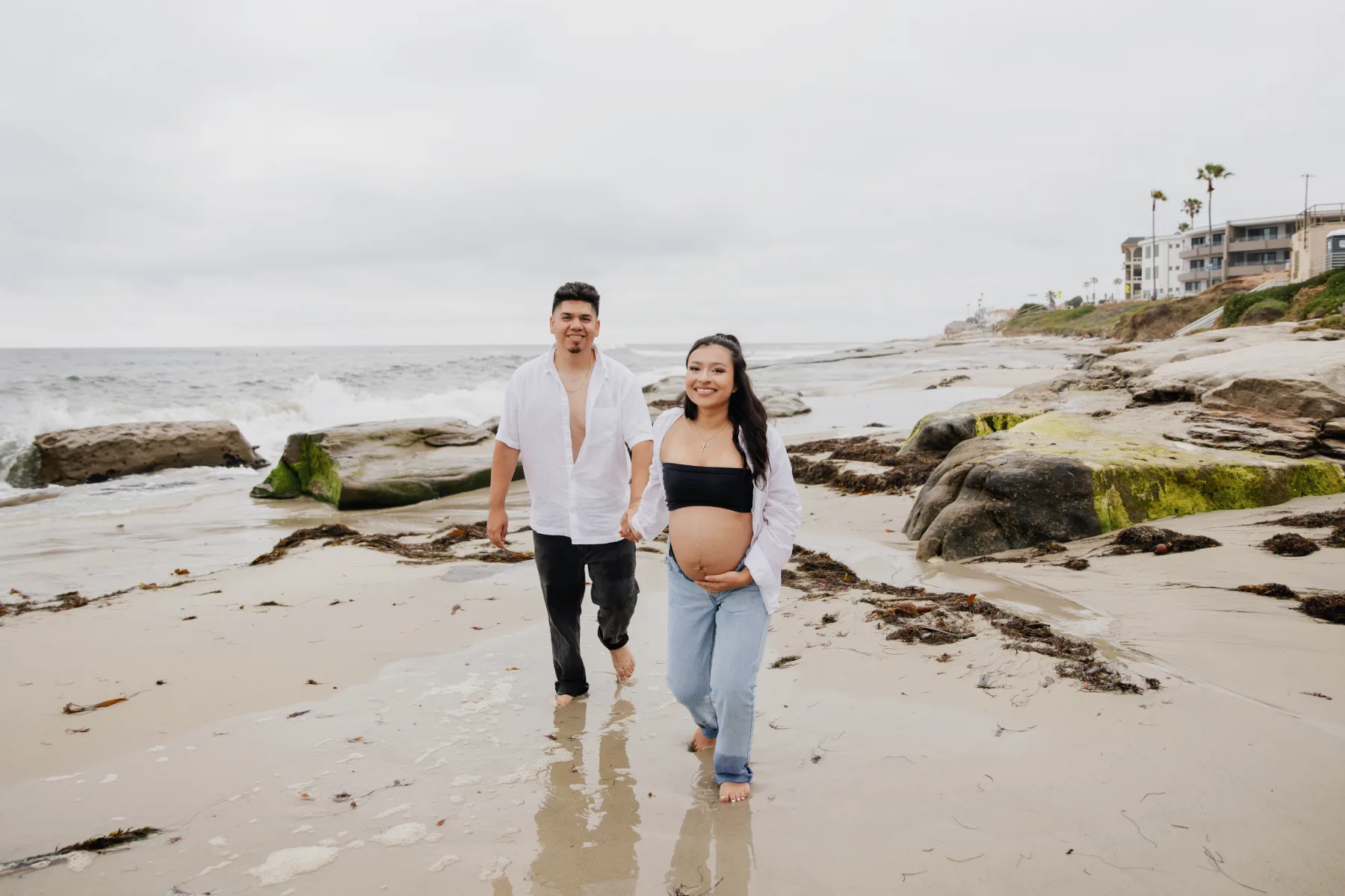 Couple walking on the beach during a maternity session in La Jolla