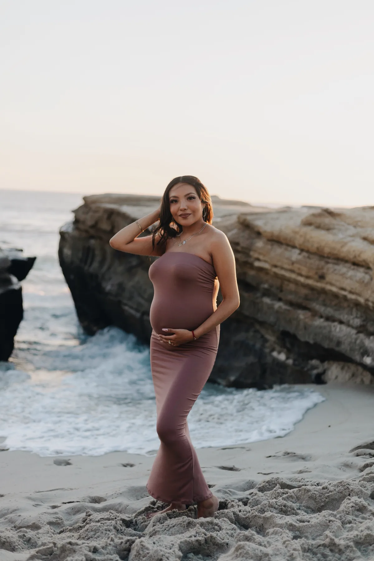Maternity portrait in a mauve gown at a La Jolla beach at sunset
